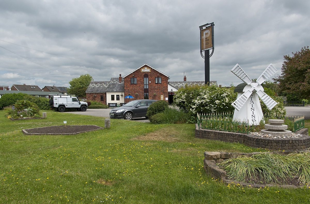 The Plough and the village green in Staining, with its model windmill